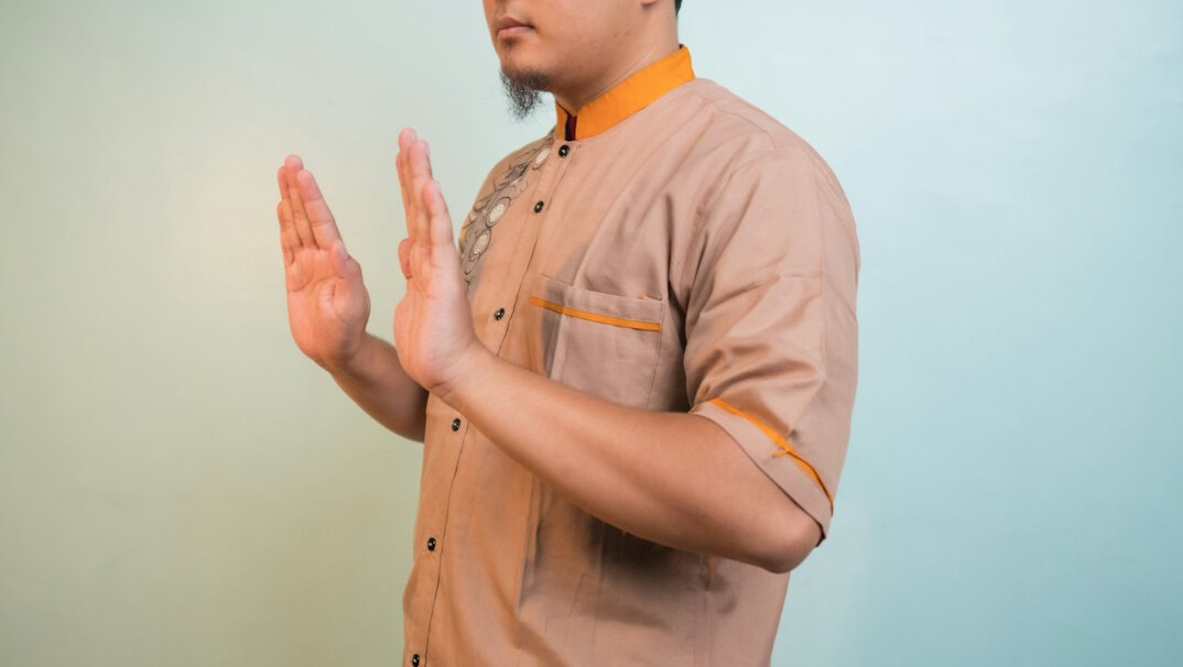 Man practicing an open-hand gesture while speaking confidently