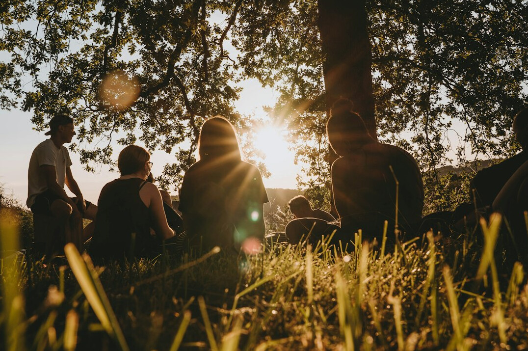 Diverse group of people talking in a warm conversation circle outdoors