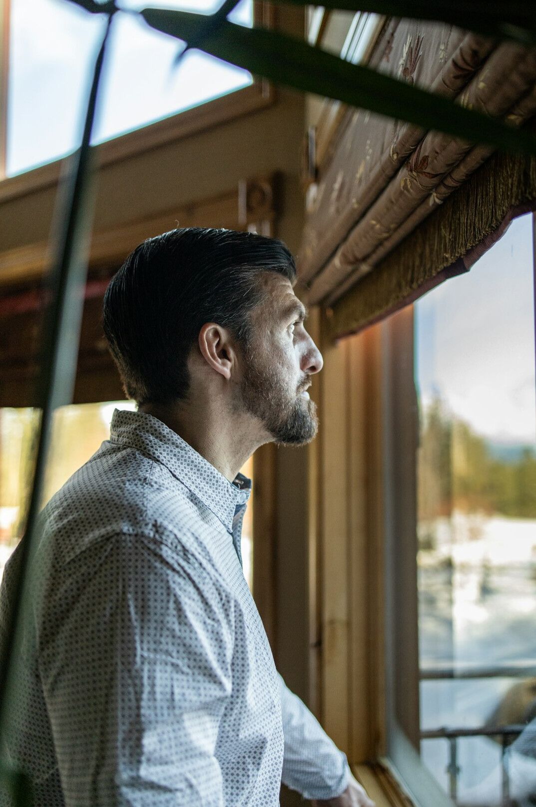Thoughtful man looking out a window in warm light